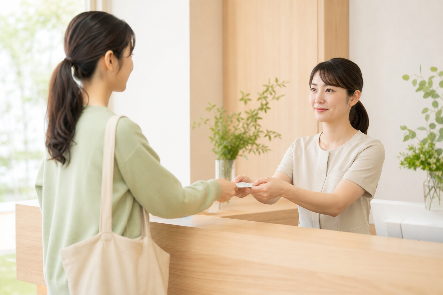 受付で保険証をお渡しする場面